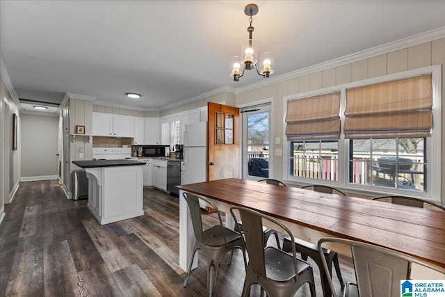 kitchen featuring dishwasher, ornamental molding, dark wood-style flooring, white cabinetry, and a notable chandelier