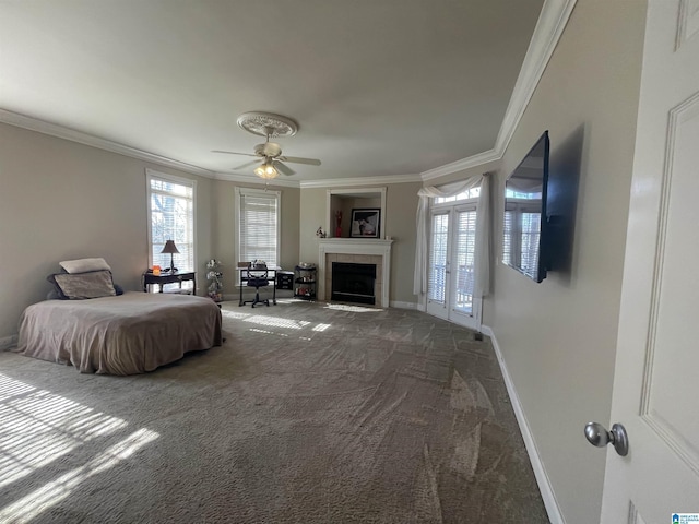 carpeted bedroom with a tiled fireplace, a ceiling fan, baseboards, and ornamental molding