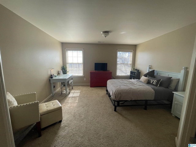 bedroom featuring multiple windows, baseboards, and light carpet