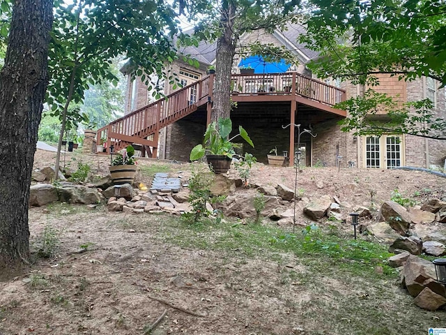 back of property with brick siding, stairway, and a deck