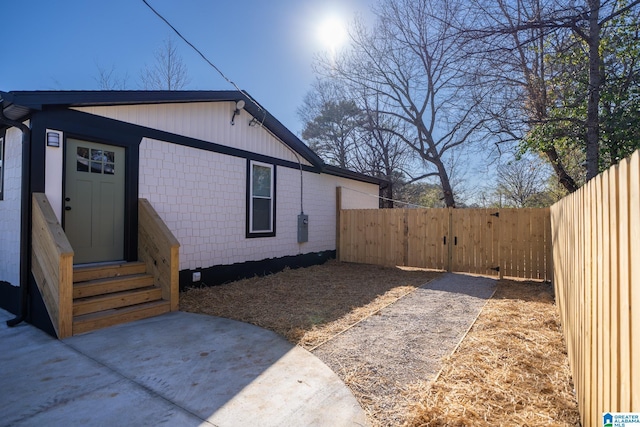 view of side of home featuring entry steps and fence