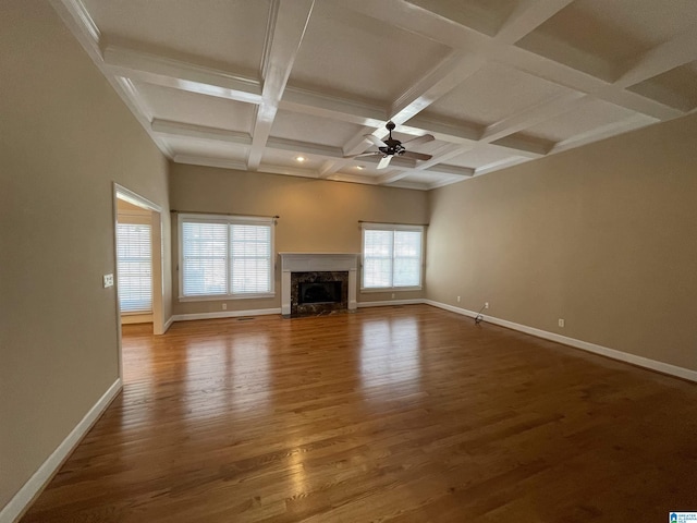 unfurnished living room featuring a fireplace, wood finished floors, a ceiling fan, and baseboards