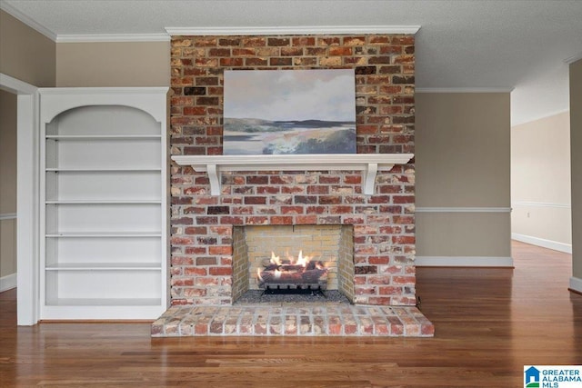 details featuring a textured ceiling, wood finished floors, built in features, ornamental molding, and a brick fireplace