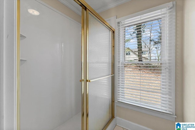 bathroom with a stall shower and crown molding