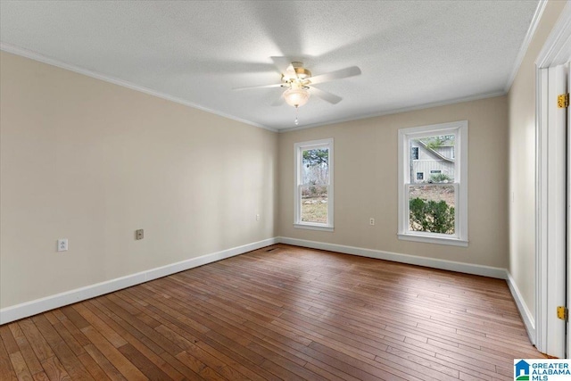 empty room with ornamental molding, hardwood / wood-style flooring, and baseboards