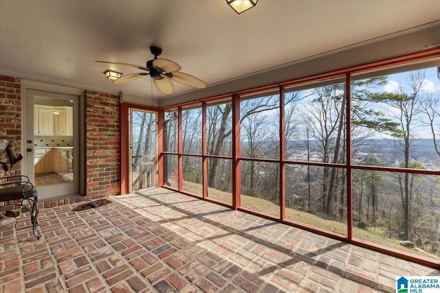 unfurnished sunroom with ceiling fan