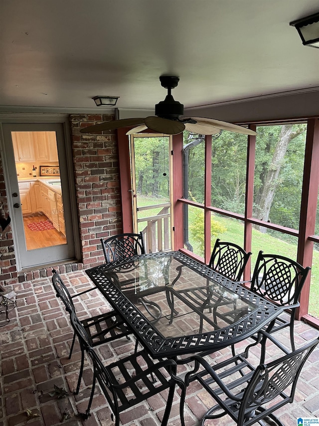 sunroom with a healthy amount of sunlight and ceiling fan
