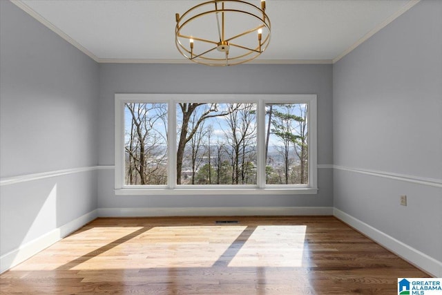 unfurnished dining area featuring a chandelier, visible vents, crown molding, and wood finished floors