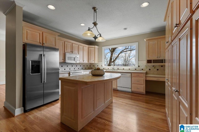 kitchen featuring white appliances, light countertops, crown molding, and wood finished floors