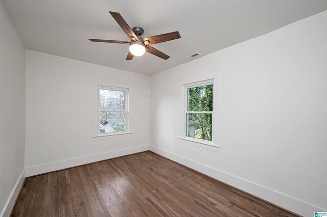 spare room featuring a wealth of natural light, visible vents, and baseboards