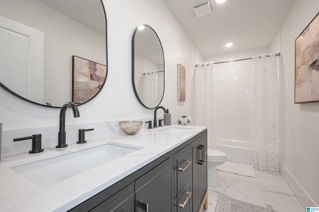 full bathroom with marble finish floor, double vanity, a sink, and toilet