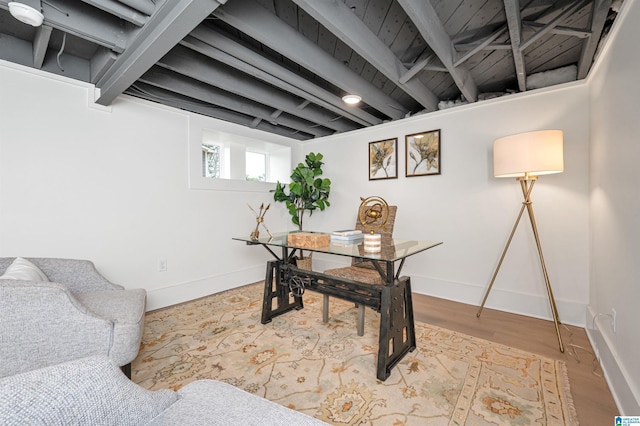 home office featuring beamed ceiling, wood finished floors, and baseboards