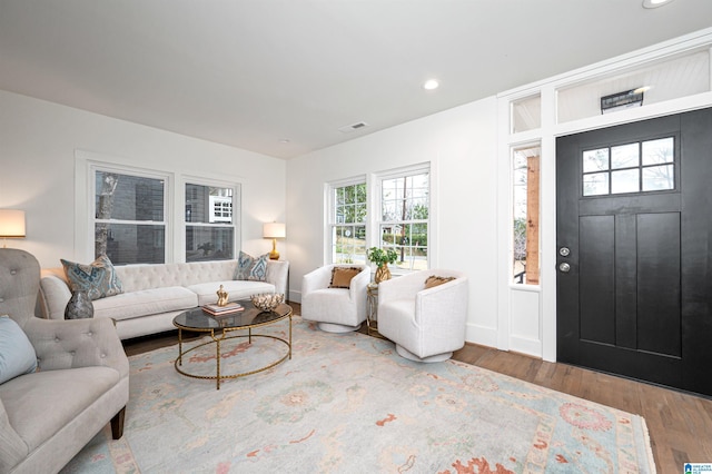 living room featuring baseboards, wood finished floors, visible vents, and recessed lighting