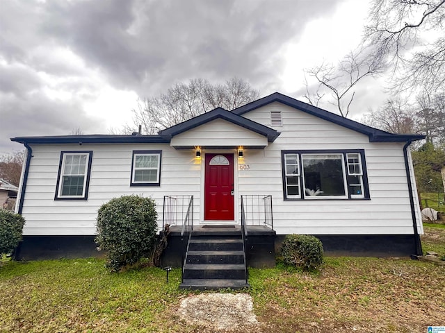 bungalow-style home with a front yard