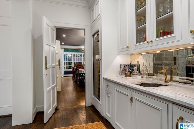 bar featuring dark wood-style floors, crown molding, recessed lighting, decorative backsplash, and a sink