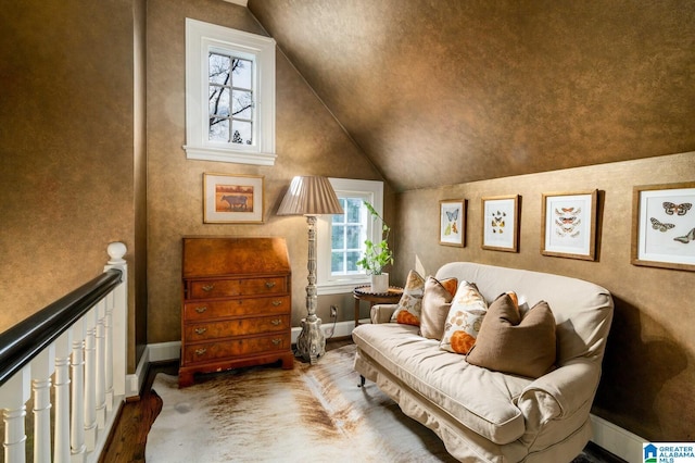 living area with lofted ceiling, an upstairs landing, and baseboards