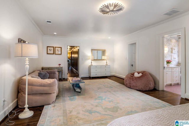 bedroom featuring baseboards, visible vents, wood finished floors, and ornamental molding