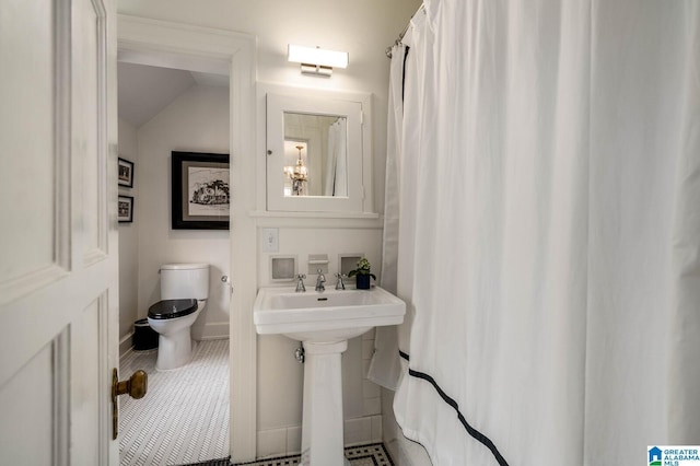 full bath with a sink, tile patterned flooring, toilet, and baseboards