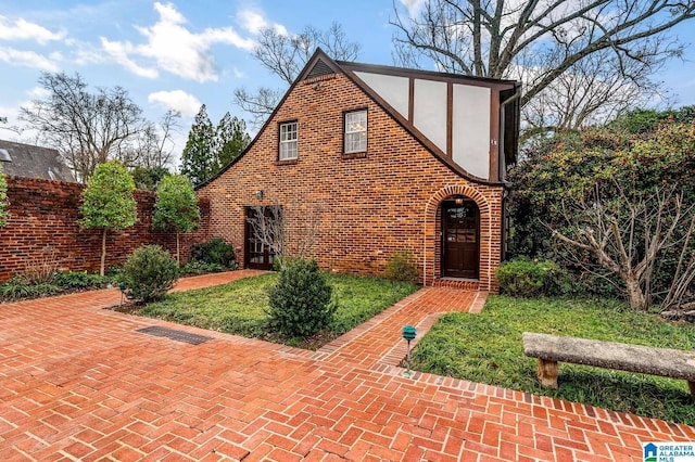 tudor-style house with brick siding and stucco siding