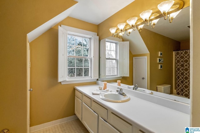 full bathroom featuring toilet, vanity, baseboards, vaulted ceiling, and tile patterned floors