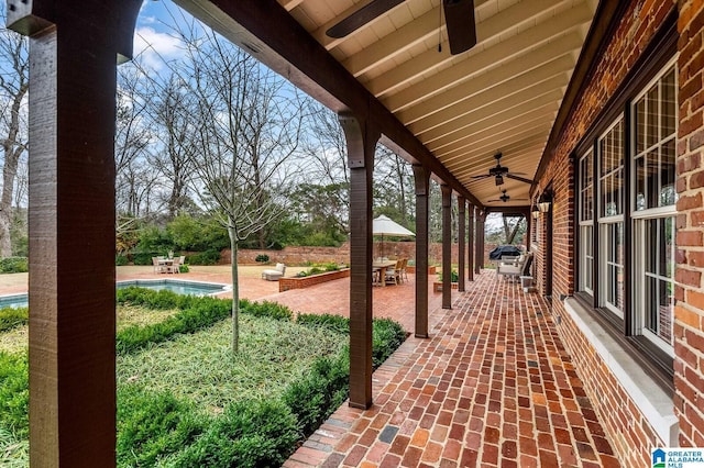 view of patio with an outdoor pool and a ceiling fan