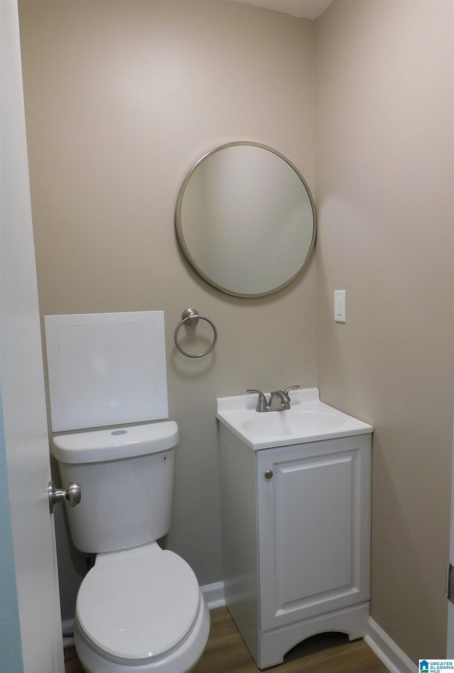 bathroom featuring wood finished floors, vanity, toilet, and baseboards