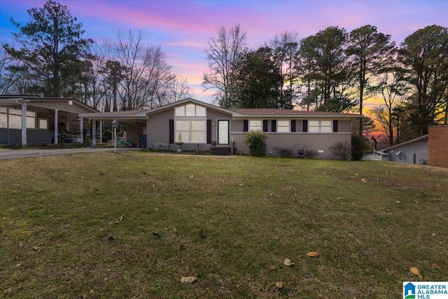 view of front of property with a carport, a front lawn, and driveway