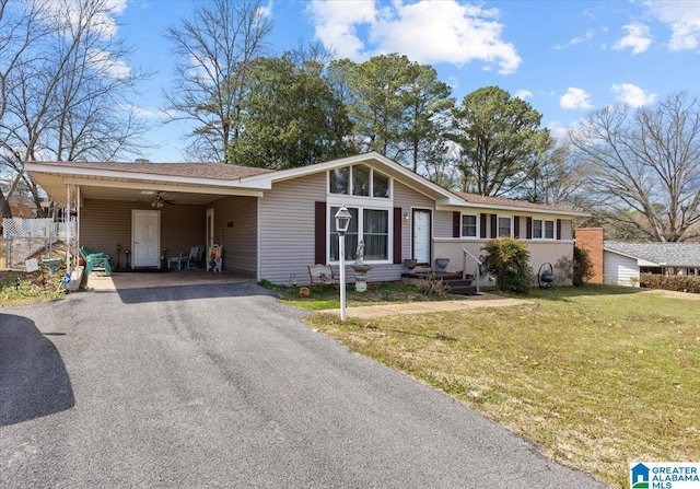 view of front facade featuring driveway, an attached carport, and a front yard