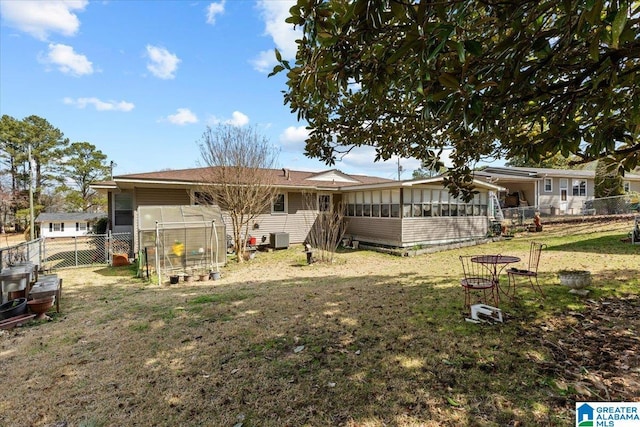 back of property featuring a yard, fence, a sunroom, and central air condition unit