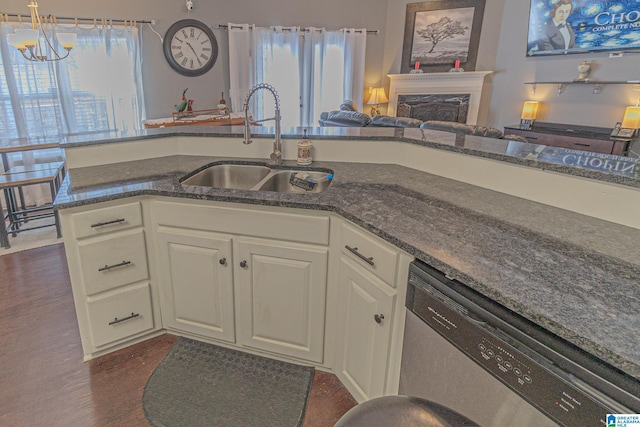 kitchen featuring a healthy amount of sunlight, dishwasher, a fireplace, and a sink