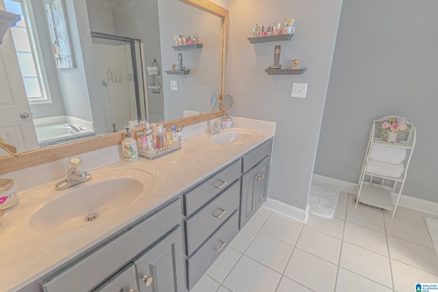 full bath with double vanity, tile patterned flooring, a shower stall, and a sink