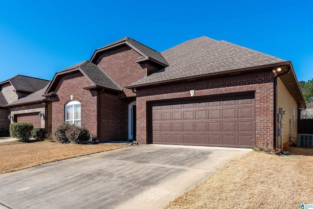 view of front of house featuring concrete driveway, a garage, brick siding, and roof with shingles