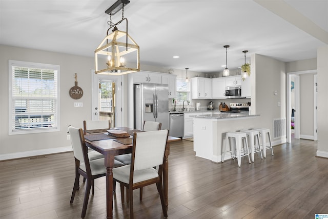 dining area featuring dark wood finished floors, visible vents, and baseboards