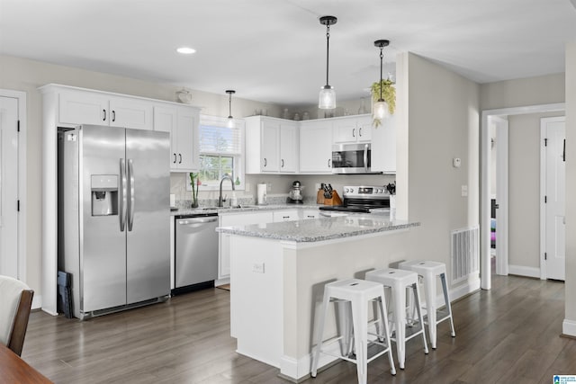 kitchen with visible vents, a sink, dark wood finished floors, stainless steel appliances, and white cabinets