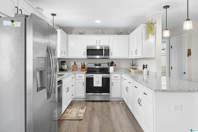 kitchen featuring a peninsula, white cabinets, and appliances with stainless steel finishes