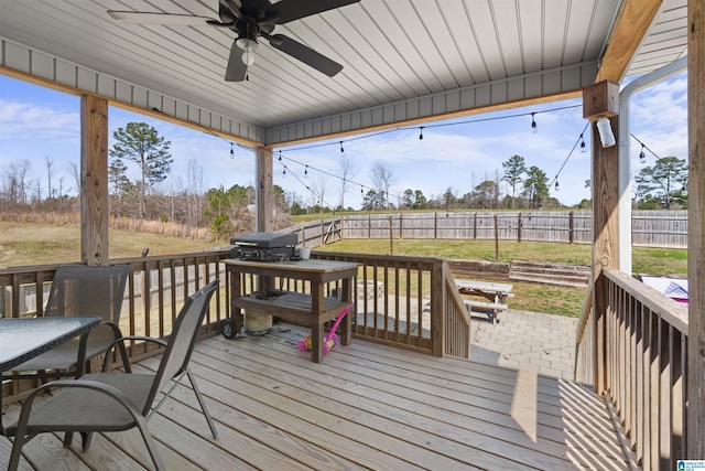 wooden deck with grilling area, a fenced backyard, a lawn, and ceiling fan