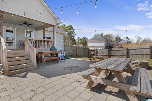 view of patio / terrace featuring outdoor dining space, a deck, a ceiling fan, and a fenced backyard