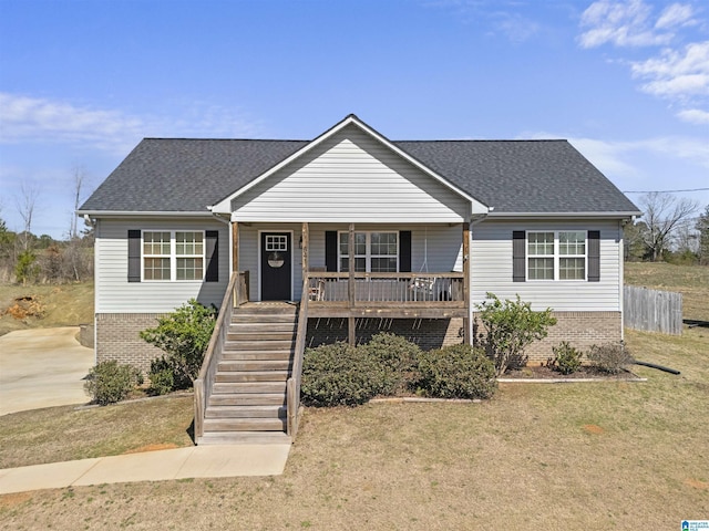 view of front of house with brick siding, covered porch, stairs, and a shingled roof