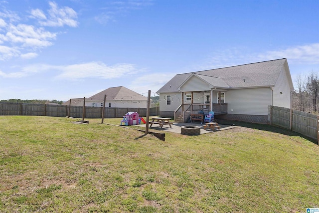 back of property featuring a patio area, a yard, a fire pit, and a fenced backyard