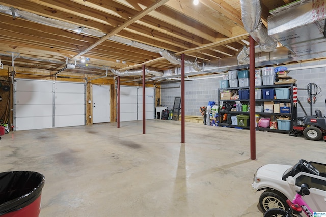 garage featuring concrete block wall and a garage door opener