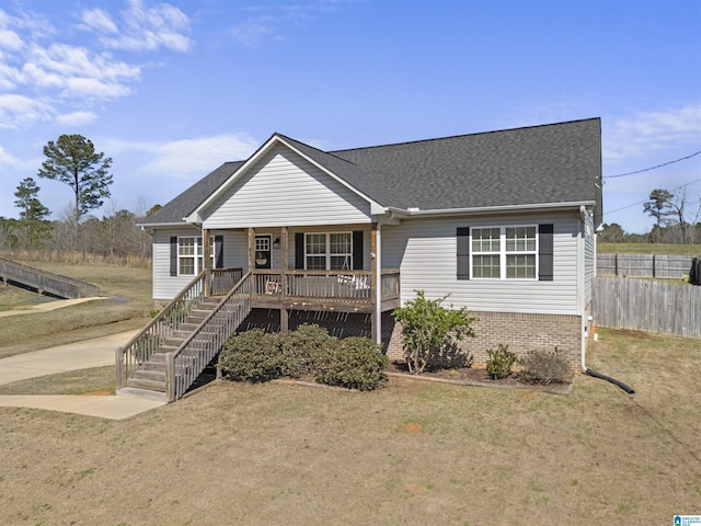 view of front of house with stairway, a porch, a front lawn, and fence