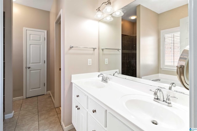 bathroom featuring baseboards, double vanity, a sink, and tile patterned floors