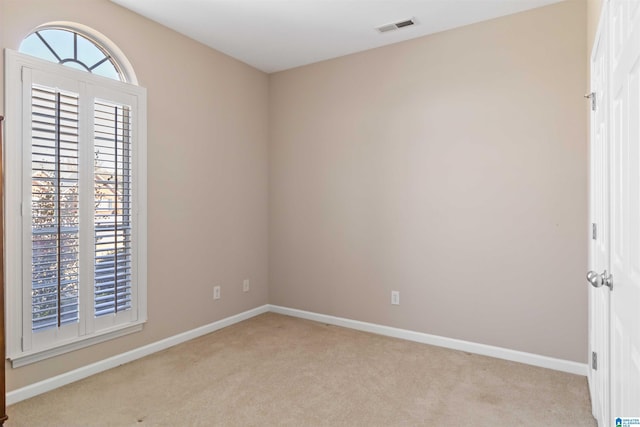 spare room with baseboards, visible vents, and carpet flooring