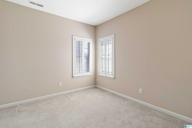 empty room featuring baseboards, visible vents, and carpet flooring