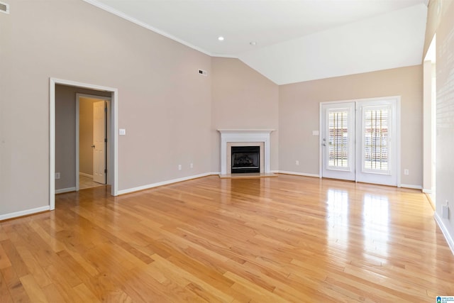 unfurnished living room featuring crown molding, a fireplace, high vaulted ceiling, light wood-type flooring, and baseboards