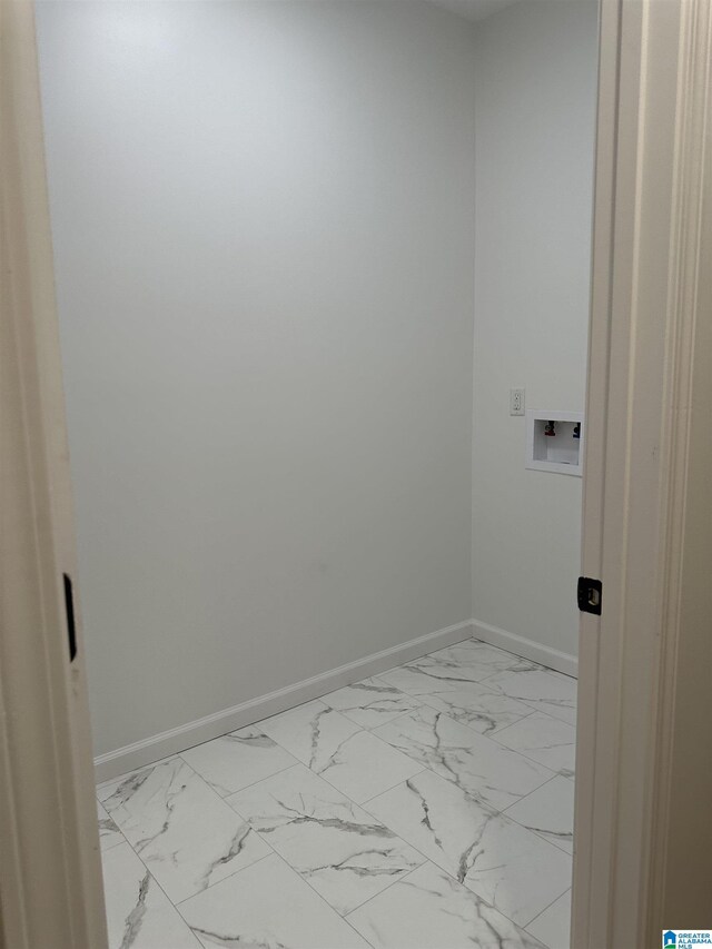 clothes washing area with laundry area, marble finish floor, and baseboards