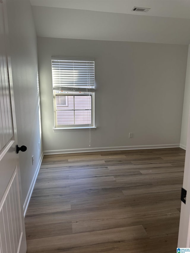 unfurnished room with visible vents, baseboards, and wood finished floors