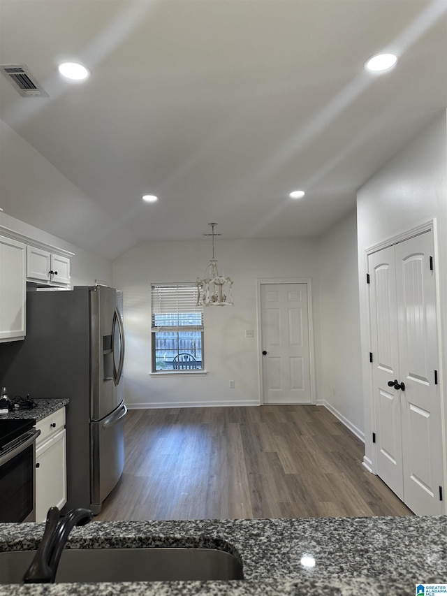 kitchen with visible vents, dark stone counters, dark wood-style floors, stainless steel stove, and white cabinetry