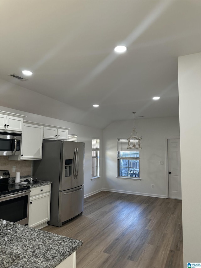 kitchen with stainless steel appliances, lofted ceiling, and white cabinets