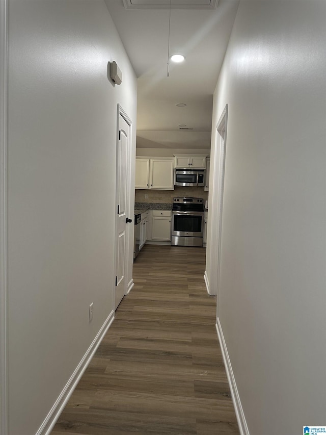 hallway with dark wood-style flooring, recessed lighting, attic access, and baseboards